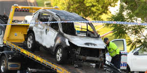 The burnt-out car is taken away from Raven Street in Camp Hill on Wednesday.