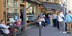 Visitors queue at a patisserie in Paris featured on the Netflix series Emily in Paris.