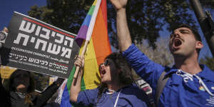 Protesters waving a rainbow flag and a sign that reads in Hebrew “the occupation corrupts” protest Benjamin Netanyahu’s new government in front of Israel’s Parliament in Jerusalem on Thursday.