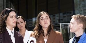 Brittany Higgins,centre,spoke outside the ACT Supreme Court after the first trial was aborted,with Heidi Yates standing on the right.