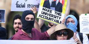 Students hold placards demanding transparency from the University of Queensland. 