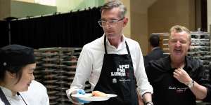 Premier Dominic Perrottet helps plate up meals for the Open For Lunch event in Sydney on Friday.