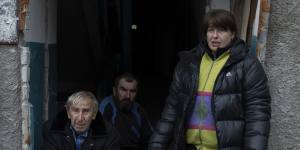 Ukrainian civilians gather at the entrance of their apartment in the recently retaken Izyum.