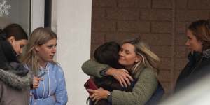 A parent hugs a child as others come to pick up students from the Meijer store in Oxford,Michigan,following an active shooter situation at Oxford High School. .