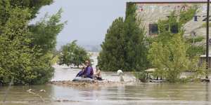 Firefighters evacuate people and dogs from a flooded building in Larissa,central Greece,on Wednesday.