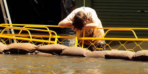A boy takes a break from sandbagging in Numurkah during the March 2012 floods. The recent inquiry concluded that council inaction had left the community exposed to a repeat of the flooding.