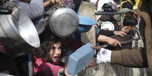 Palestinians line up for food amid the Israeli air and ground offensive.