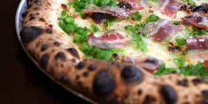 The piselli pizza merges pancetta,peas,mint,fior di latte and parmigiano.