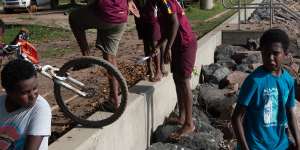 Children playing on the already breached sea wall on Saibai Island.