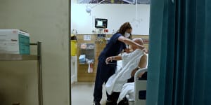 A registered nurse tends to a patient in the emergency rooms at St Vincent’s Hospital.