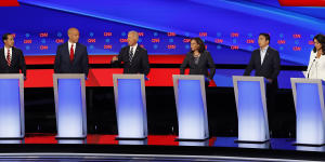 Tulsi Gabbard (in white) and Democratic candidates assembled for a presidential primary debate in 2019.