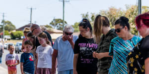 Mourners visit the makeshift memorial site at Hillcrest Primary School.