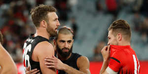 Adam Saad is congratulated by former Bombers team mates Cale Hooker and David Zaharakis. 