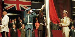 Members of the combined Chinese Armed Forces colourguard raise the Chinese flag in Hong Kong on June 30,1997,marking the moment the former British colony was handed over to Beijing. Prince Charles is in the lower right-hand corner.