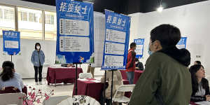 Graduates look for work at a job fair in Beijing. 