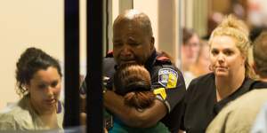 A Dallas Area Rapid Transit police officer receives comfort at the Baylor University Hospital emergency room entrance.