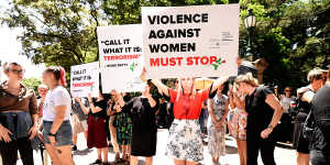 Protesters hold placards during a domestic violence protest organised by the Red Rose Foundation in Brisbane on Friday.