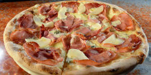 Smoky speck pizza scattered with pear and gorgonzola.