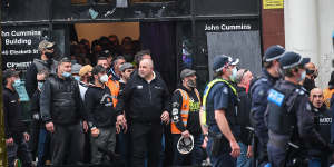 Police keep protesters away from the office of the CFMEU in Melbourne on Monday.