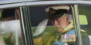 King Charles III salutes as he leaves Westminster Abbey.
