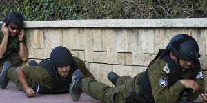 Israeli soldiers take cover as a siren sounds a warning of incoming rockets fired from the Gaza strip.