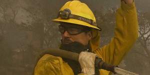 A firefighter asks for more water as his hose goes dry along Highland Avenue in Los Angeles.