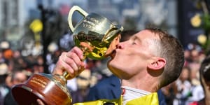 Jockey Mark Zahra kisses the cup after winning the Melbourne Cup on Without A Fight.
