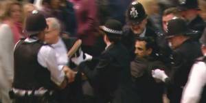 A screen grab of police at Westminster Hall wrestling a man to the ground after he rushed towards the Queen’s coffin and tried to pull at the flag draped over it. 