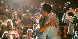 Chris Isaak embraces a fan during the show. 