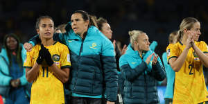 Mary Fowler of Australia is embraced by Lydia Williams as players of Australia applaud the fans after defeat to England.