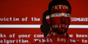 A message from the NotPetya worm projected on a young man;the attack used a variant of the ransomware Petya to destroy computers.