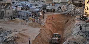 Palestinians watch members of Hamas searching for bodies of hostages in Khan Younis.