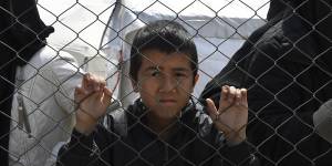 Foreign ISIS wives and children at the fence line of the Foreign section of al-Hawl camp.