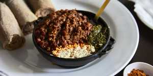 Special kitfo - finely chopped,spiced raw beef with gomen (sauteed kale) and ayip (Ethiopia’s answer to cottage cheese).