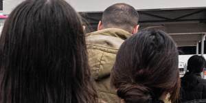 Commuters queue to catch a pink replacement bus outside Bankstown station.