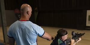 King practises at the Sydney International Shooting Centre,accompanied by a support worker.