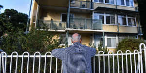 A resident of the old North Melbourne housing estate looks at his home in 2018.