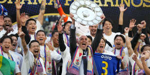 Kevin Muscat lifts the J.League trophy with Yokohama F. Marinos last weekend.
