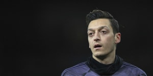 Arsenal's Mesut Ozil warms up prior the English Premier League soccer match between Arsenal and Manchester City,that was pulled off Chinese TV.