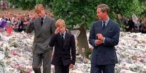 William and Harry are accompanied by Charles as they inspect the flowers placed outside Kensington Palace in memory of Diana
