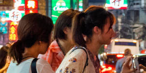 Tourists haggle over the price of a tuk tuk in Bangkok.