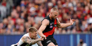 Jordan De Goey stretches to tackle Essendon star Jake Stringer on Anzac Day.