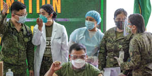 Philippine Army Commanding General Jose Faustino jnr poses with a vial of Sinovac Biotech’s CoronaVac,after being vaccinated last month.