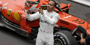 Mercedes driver Lewis Hamilton holds his red helmet to tribute Niki Lauda after he won the Monaco Grand Prix.