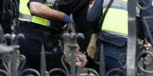 A woman is detained by Victoria Police on August 09,2020.