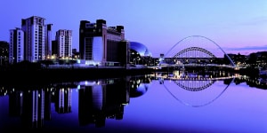 Newcastle by night:The redeveloped Tyne River waterfront and Gateshead Millennium Bridge.