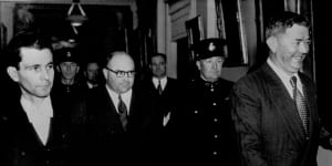 The Serjeant-at-Arms,Jack Pettifer (left) escorts Frank Browne (wearing spectacles) and Raymond Fitzpatrick (in front) from King's Hall,Parliament House,after the House of Representatives had ordered that they be imprisoned for three months. 