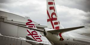 Virgin Australia jets grounded at Melbourne Airport on Tuesday. The airport is pushing for the airline to move south,amid a bidding war from state governments. 