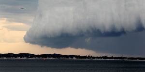 A Qantas plane approaches a storm over Sydney Airport in 2014.