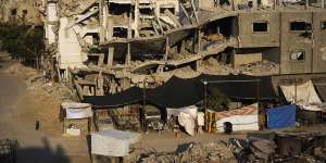 Palestinians walk through the destruction following an Israeli air and ground offensive in Khan Younis,southern Gaza Strip.